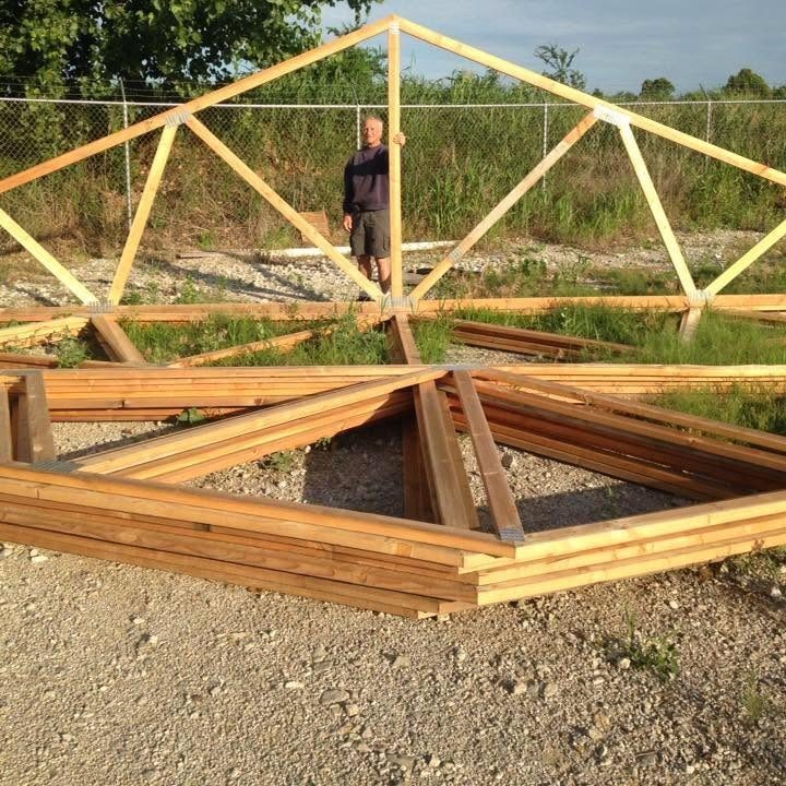 Lakeside Metal owner standing with wood roof trusses in the yard