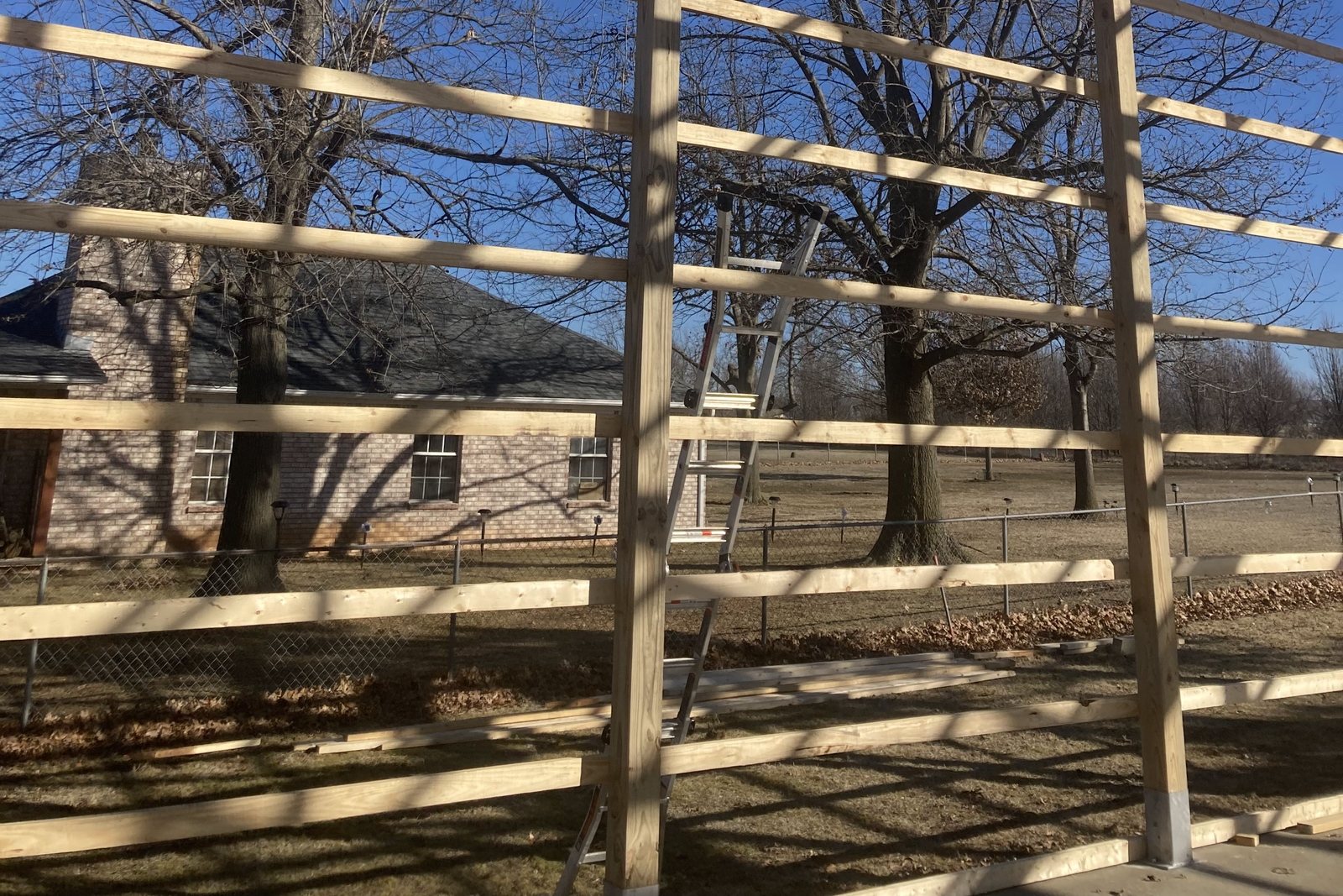 Wood post frame of a barn standing against a clear sky