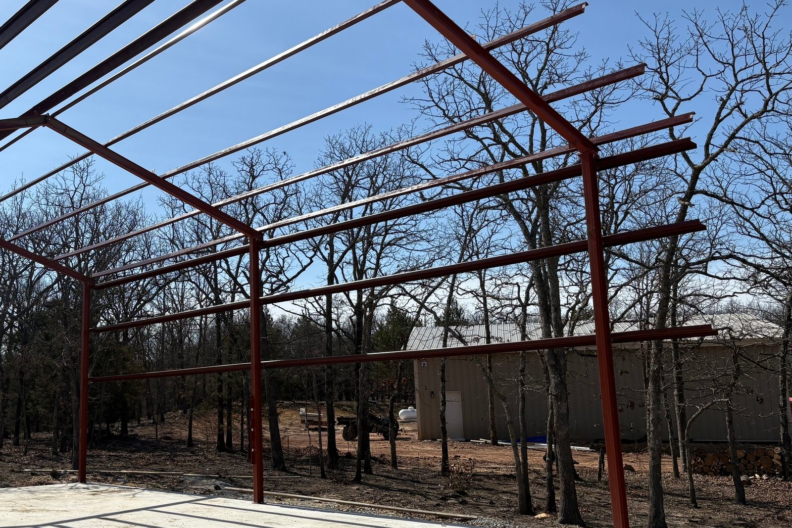 Red steel building frame standing on a new concrete slab
